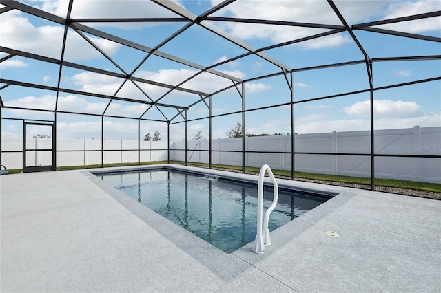 view of pool with glass enclosure and a patio