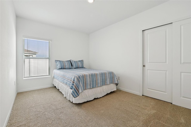 bedroom featuring light carpet and a closet