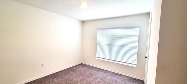 spare room featuring carpet and a textured ceiling