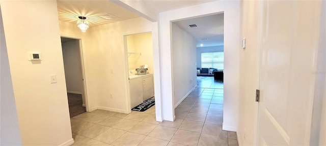 hallway with light tile patterned floors and independent washer and dryer