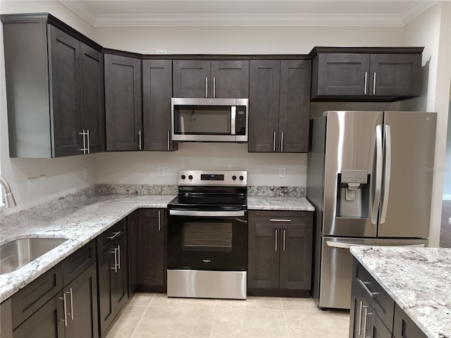 kitchen with appliances with stainless steel finishes, dark brown cabinets, and sink