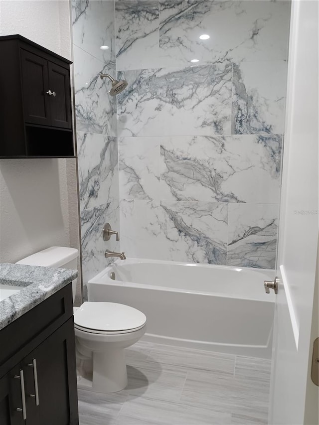 full bathroom featuring tiled shower / bath combo, vanity, and toilet