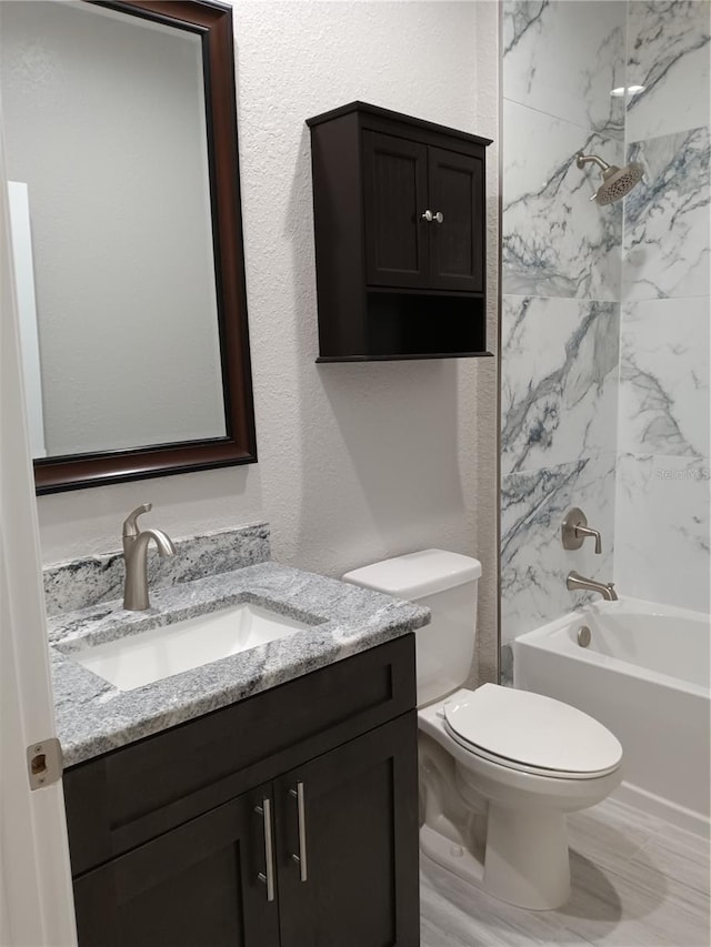 full bathroom with toilet, vanity, and tiled shower / bath