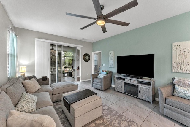 living room featuring light tile patterned floors, ceiling fan, and a healthy amount of sunlight