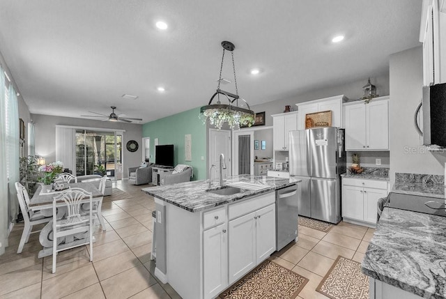 kitchen with white cabinets, pendant lighting, stainless steel appliances, and a kitchen island with sink