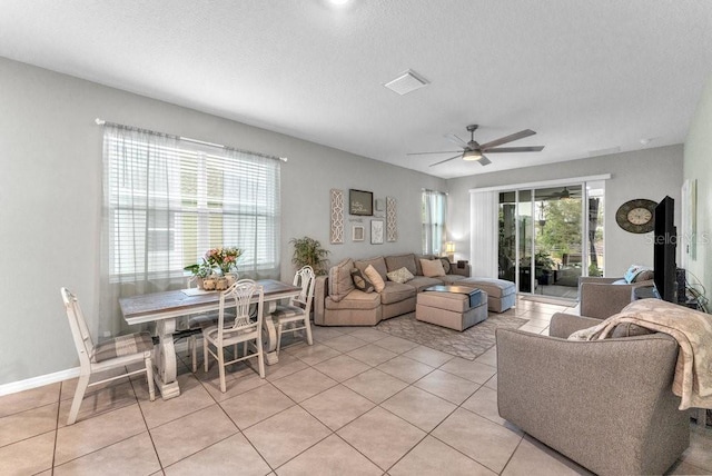 tiled living room featuring a textured ceiling and ceiling fan