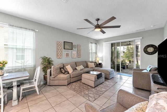 tiled living room with a textured ceiling and ceiling fan