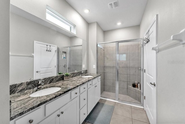 bathroom featuring tile patterned flooring, vanity, and an enclosed shower