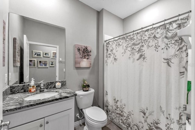 bathroom featuring vanity, toilet, and walk in shower