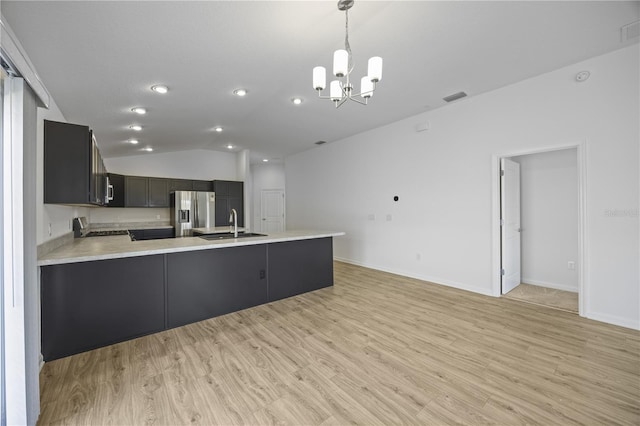 kitchen with kitchen peninsula, stainless steel refrigerator with ice dispenser, sink, light hardwood / wood-style floors, and lofted ceiling