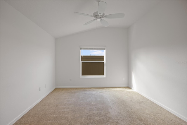 spare room with ceiling fan, light colored carpet, and lofted ceiling