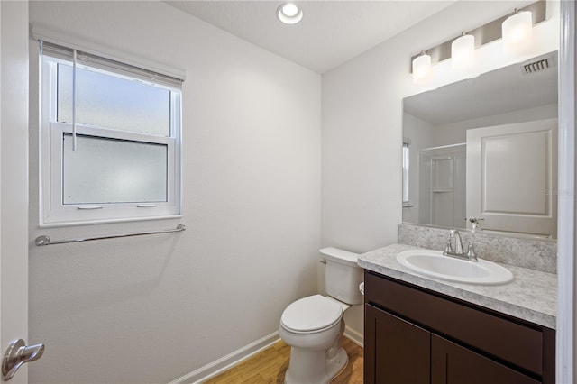 bathroom with walk in shower, vanity, wood-type flooring, and toilet