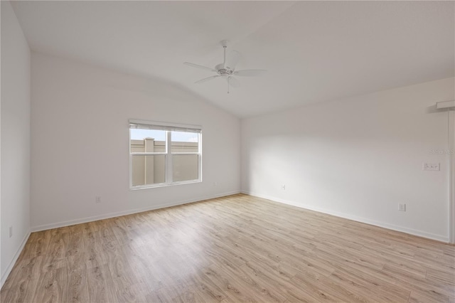 spare room with ceiling fan, lofted ceiling, and light wood-type flooring