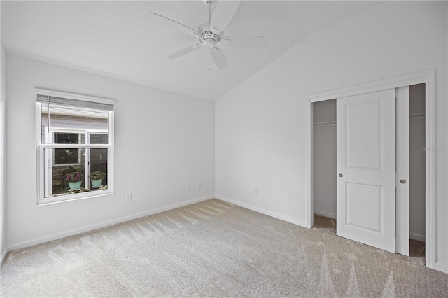 unfurnished bedroom featuring ceiling fan, a closet, light carpet, and vaulted ceiling