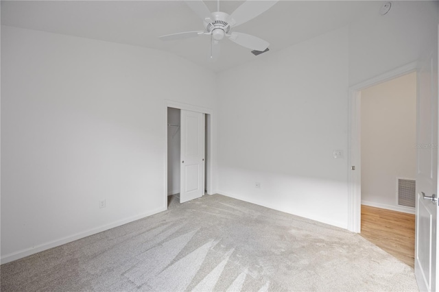 spare room with ceiling fan, light colored carpet, and lofted ceiling