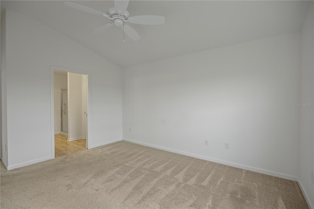 carpeted spare room featuring vaulted ceiling and ceiling fan