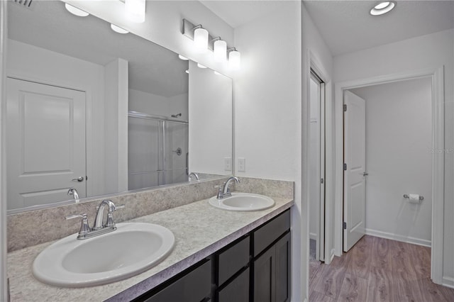 bathroom featuring wood-type flooring, vanity, and an enclosed shower