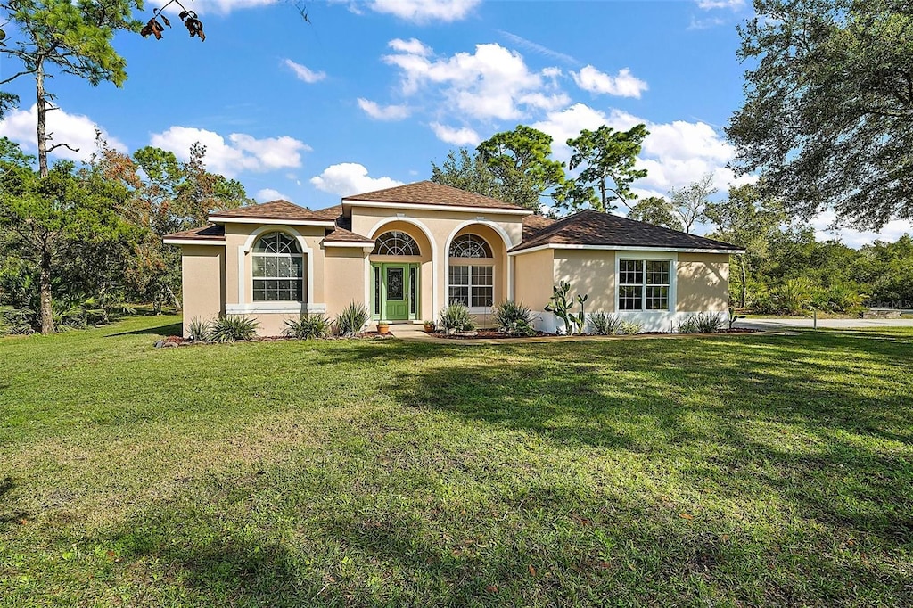 mediterranean / spanish house featuring a front lawn