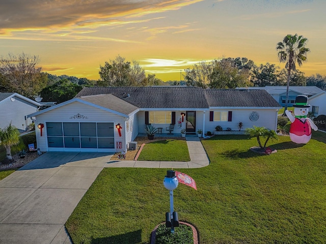 ranch-style home with a yard, a porch, and a garage