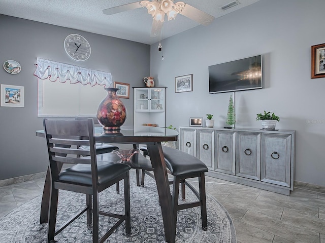 dining room featuring ceiling fan and a textured ceiling