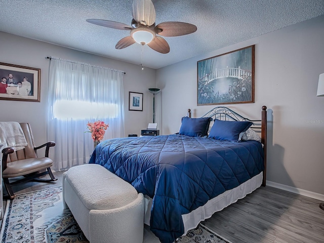 bedroom featuring hardwood / wood-style floors, a textured ceiling, and ceiling fan