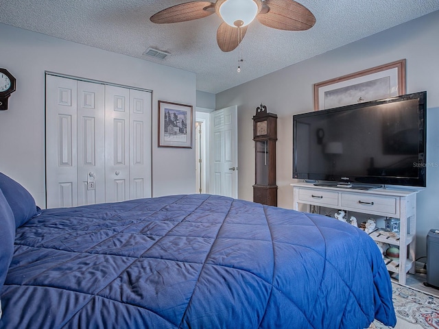 bedroom featuring ceiling fan, a closet, and a textured ceiling