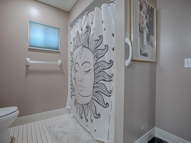 bathroom with a shower with curtain, tile patterned floors, a textured ceiling, and toilet