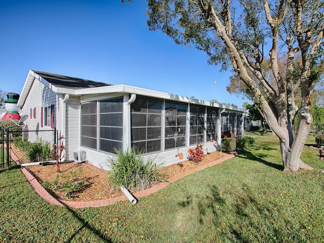 rear view of house with a sunroom and a yard