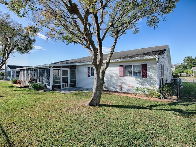 back of property with a yard and a sunroom