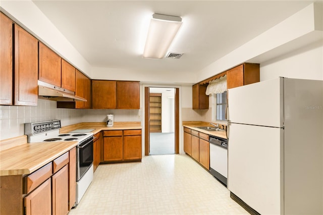 kitchen with white appliances, backsplash, and sink