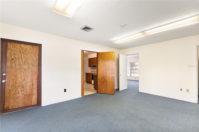 unfurnished bedroom with ensuite bath and dark carpet