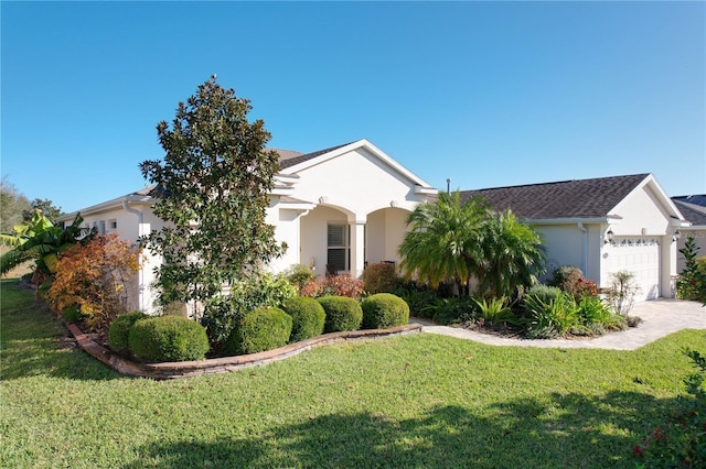 ranch-style home with a garage and a front lawn