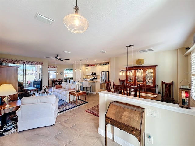 tiled living room featuring ceiling fan