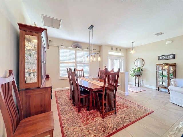 dining area featuring a notable chandelier and light tile patterned flooring