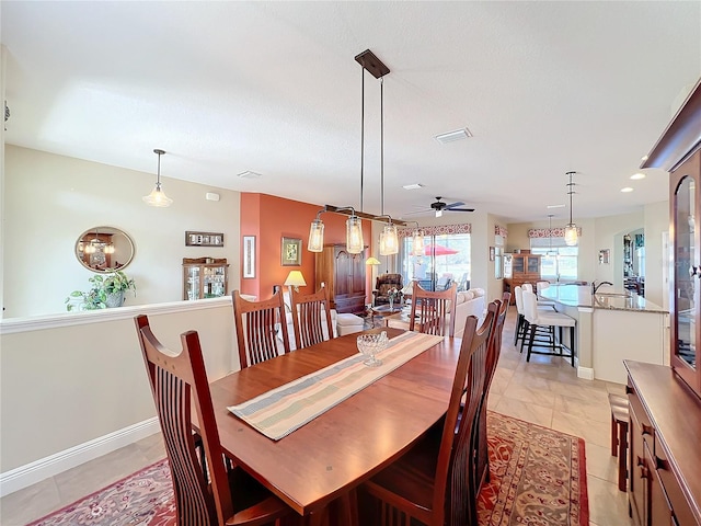 tiled dining space with ceiling fan