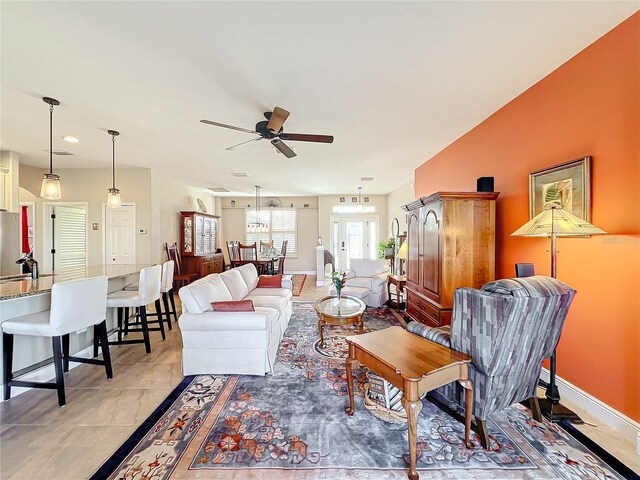 living room with ceiling fan, french doors, light tile patterned floors, and sink