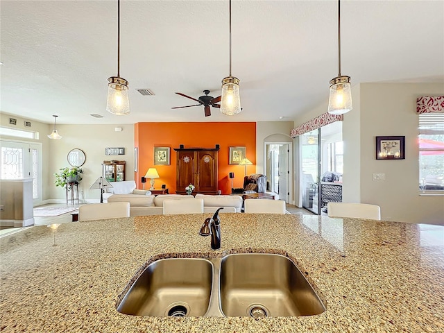 kitchen featuring decorative light fixtures, ceiling fan, a healthy amount of sunlight, and sink