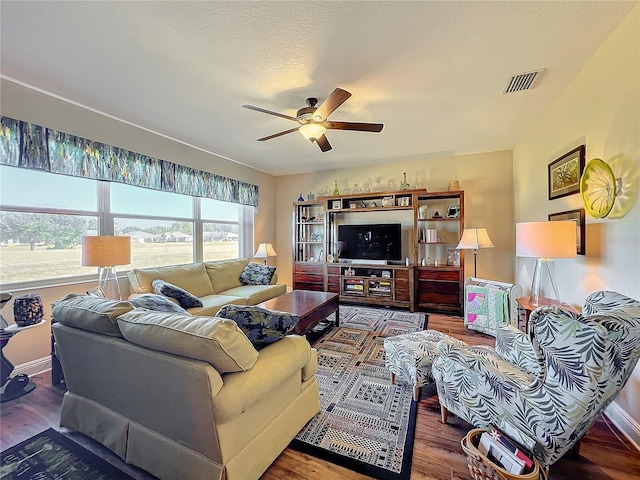 living room with hardwood / wood-style floors, ceiling fan, and a textured ceiling