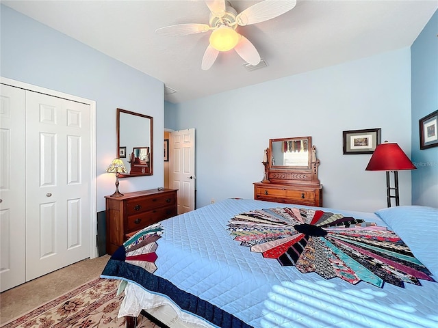 carpeted bedroom with ceiling fan and a closet