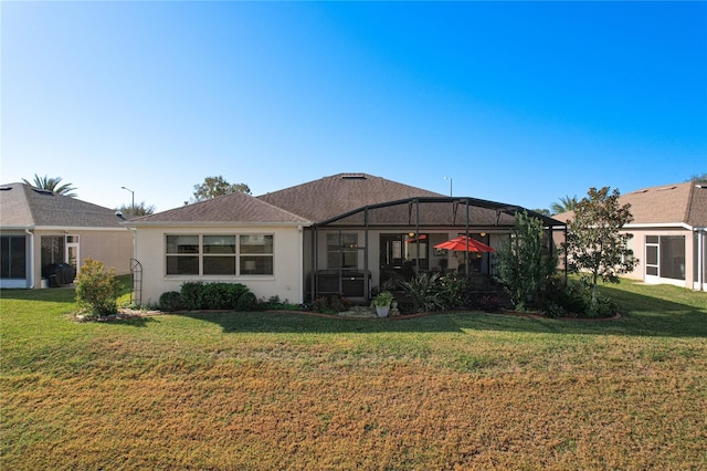 rear view of property with a lawn and glass enclosure