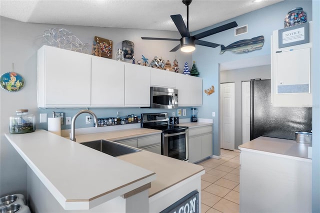 kitchen with stainless steel appliances, ceiling fan, sink, light tile patterned floors, and white cabinetry