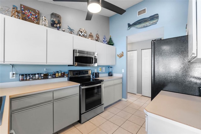 kitchen with ceiling fan, light tile patterned flooring, white cabinetry, and appliances with stainless steel finishes