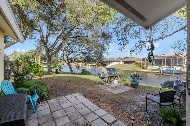 view of patio with area for grilling and a water view