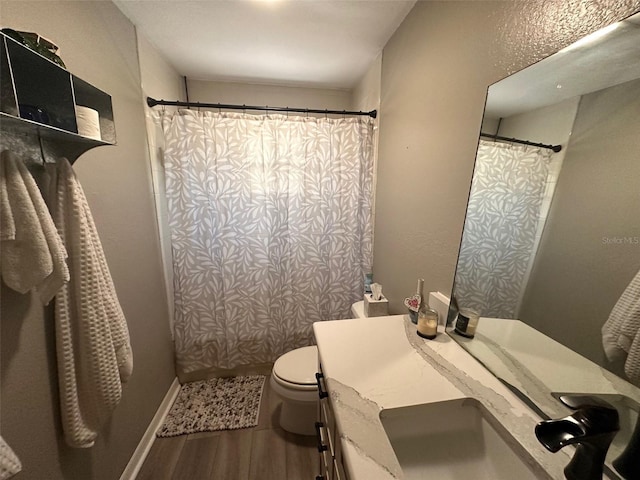 bathroom with hardwood / wood-style floors, vanity, curtained shower, and toilet