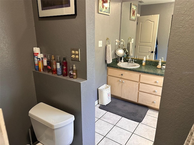 bathroom with tile patterned flooring, vanity, and toilet