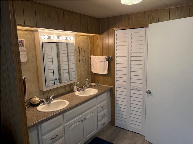 bathroom with hardwood / wood-style floors, vanity, and wood walls