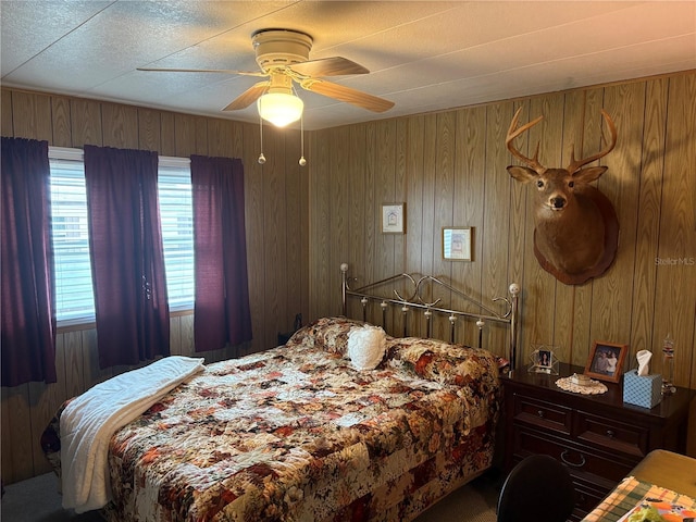 bedroom featuring carpet, ceiling fan, and wooden walls