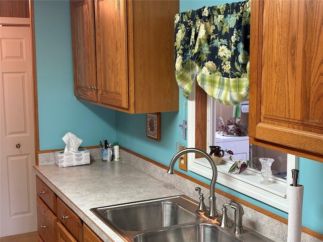 kitchen featuring washer / clothes dryer and sink