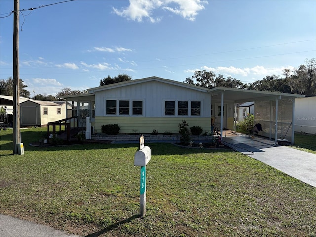 manufactured / mobile home with a carport and a front lawn