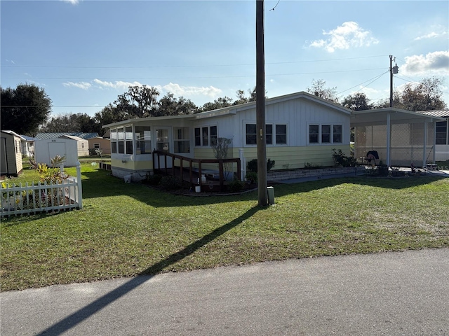 manufactured / mobile home featuring a storage unit and a front lawn